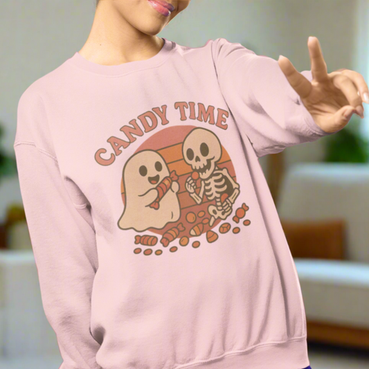 Person wearing a pink sweatshirt with a Halloween-themed graphic of a ghost and skeleton.